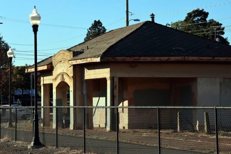 The shuttered historic Healdsburg train depot behind a chain-link fence
